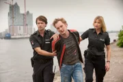Mattes (Matthias Schloo, l.) und Melanie (Sanna Englund, r.) setzen einen möglichen Erpresser (Christian Blümel, M.) fest.