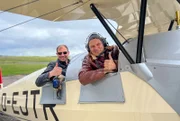 André Gatzke (r.) steigt in ein historisches Flugzeug und schaut sich das langgezogene Eiland aus der Luft an.