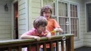 Hemphill family sons blow bubbles on the back porch in family package segment in episode 209, as seen on HGTV's House Hunters Family