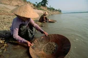 March 1992, north of Pak-Ou, Laos --- Woman Panning for Gold --- Image by © Michael S. Yamashita/CORBIS