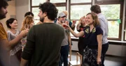 Anita (Nadja Becker) verkündet stolz ihre Schwangerschaft und stößt auf diese mit den Mitgliedern der Elterninitiative an.