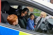Rana (Taj Atwal) hat sich überreden lassen, beim Schulfest den Kindern ihren Streifenwagen zu zeigen.