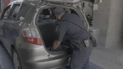 Officer Watkins checks the trunk of a car. (National Geographic)