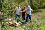 Svend Feuerbach zeigt Irmgards Gästen das neue Kräuterbeet.