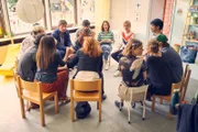 In der monatlichen Elternversammlung wird hitzig über die Suche nach einem neuen Erzieher diskutiert.