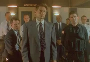 Mulder (David Duchovny, vorne) und ein ganzes Team von FBI-Leuten verhandeln mit dem Geiselnehmer, der behauptet, unter der Kontrolle von Außerirdischen zu stehen.
