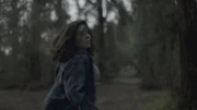 A woman fleeing coyotes in the woods.