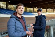 Ralf Krieger (Johannes Kienast, l.) und Tharde Rickling (Fred Costea, r.) bemerken die Polizeipräsenz im Bahnrad Stadion.