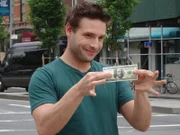 BROOKLYN, NY - Magician Eric Leclerc holds up a 100 dollar bill with a menacing look on his face before "Dollar to Burn," where he seemingly lights legal tender on fire.