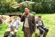 Erst als Kuno (Sven Walser, Mi.) mit Gerlinde telefoniert und sie Adsche (Peter Heinrich Brix, l.) und Brakelmann (Jan Fedder, r.) Unterhaltszahlungen in Aussicht stellt, widmen sich die beiden ihrem Enkel mit größerem Engagement.