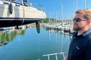 Hafenmeister Tim Fladung im Passathafen beim Kranen eines Segelbootes