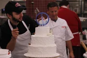 Ralph and Joe adding sculpted animals to cake.