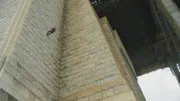 Ein Mitglied des Polizei-Rettungsteams klettert mit einem Seil die Wand hinunter.