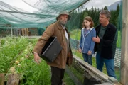 Martin Gruber (Hans Sigl, r.) drängt Anton Grainer (Peter Kremer, r.) dazu, Emmi Neumann (Lotta Herzog, M.) und ihre kranke Mutter zu unterstützen.