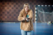 In einer Turnhalle hält die Schülerin Nathalie (Vilda Schubert) ein Gewehr in der Hand.