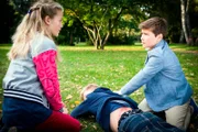 Stella (Zoë Malia Moon, li.) und Ramin (Jann Piet, re.) sind entsetzt als sie die roten Striemen auf Toms (Vincent Grages, Mitte) Rücken sehen.