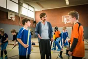 Hockeytrainer John (Andreas Nickl) versucht, den Streit zwischen Ramin (Jann Piet, links) und Tom (Vincent Grages) zu schlichten.