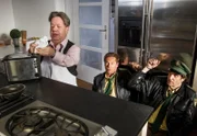 Hubert (Christian Tramitz, Mitte) und Staller (Helmfried von Lüttichau, rechts) haben sich von Manuel von Kunkel (Hans Peter Luppa, links) überrumpeln lassen. Dieser steckt Servietten in einen Toaster, um einen Brand auszulösen.