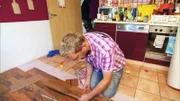 Dominik verlegt in der Küche einen neuen Boden.
