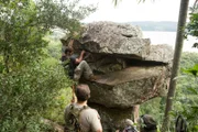 Brett Tutor scales the stone marker for closer examination.