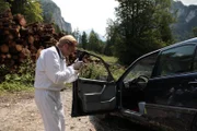 Spurensicherer Franz Wohlfahrt (Helmut Bohatsch) macht Fotos vom Tatort, es gibt zwei Tote, einer davon am Beifahrersitz des Autos.