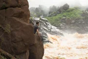 Brett Tutor prepares to jump into the raging river to retrieve Cork Graham's backpack.