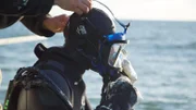Andy Kelly helps Kris Kelly with his dive mask.