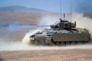 M-2 Bradley Infantry Fighting Vehicle fires its M-242 25mm Gun in the desert