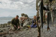 Reenactors Wikinger, die eine Mahlzeit zubereiten.