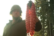 Gerrid holding up a fish that he has processed.