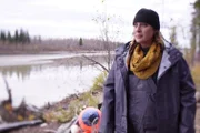 Jennifer standing next to boat buoys along Tanana River