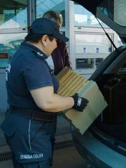 Der Grenzbeamte kontrolliert den Inhalt des Kofferraums.
