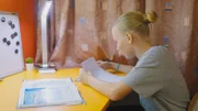 Tessa in ihrem Zimmer bei den Hausaufgaben.