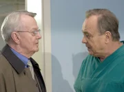 Professor Simoni (Dieter Bellmann, re.) konfrontiert mit dem Gerücht, das Simonis Schwerhörigkeit und die Komplikationen bei Bertas Operation zusammenhängen.