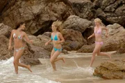 Die drei Mädchen Cleo (Phoebe Tonkin, l.), Emma (Claire Holt, m.) und Rikki (Cariba Heine, r.) springen fröhlich ins Meer, um dort als Meerjungfrauen eine ausgedehnte Entdeckungstour zu unternehmen.