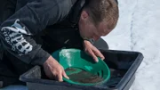 Kris Kellys pans out more material in a water basin.