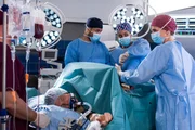Die Ärzte müssen Thorsten notoperieren; ein Pfahl hat sich durch den Unterleib gebohrt. V.l.n.r. Komparse, Thorsten Schwartz (Laurens Walter), Dr. Matteo Moreau (Mike Adler), Vivienne Kling (Jane Chirwa), Dr. Franziska Ruhland (Gunda Ebert).