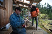 PORT PROTECTION, ALASKA- Sam Carlson and Stuart Andrews mill wood for the platform of Sam's new water tower in Port Protection, AK. (Photo Credit: National Geographic Channels/ Rick Rojass)