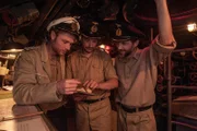 Ein U-Boot-Kommandant und zwei Offiziere beim Bestimmen eines gesichteten Schiffes.