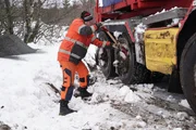 Jo Roger works on digging snow that has gotten packed in the wheels in Oestre, Naeroeysund, Norway. (National Geographic)