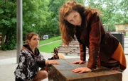 Emma Brückner (Vivien Sczesny, li.) unterstützt Anke Baumeister (Amy Benkenstein, re.) bei der Organisation ihrer Spendenveranstaltung. Doch als Anke erneut die Beine versagen, bleibt Emma nichts anderes übrig, als sie zurück in die Sachsenklinik zu bringen.