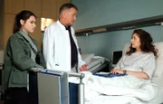 Dr. Roland Heilmann (Thomas Rühmann, mi.) vermutet, dass die Zyste, die die Ärzte an Anke Baumeisters (Amy Benkenstein, re.) Wirbelsäule gefunden haben, auch Bandwurmeier sein könnten. Anke hat einen Hund und engagiert sich in einem Tierheim. Auch Emma Brückner (Vivien Sczesny, li.) muss sich darauf testen lassen.