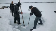 Brad Kelly watches as his sons Kris Kelly and Andy Kelly work to make a dive hole.