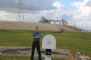 Sean stands at Launch Pad39B with the fire trenches behind him