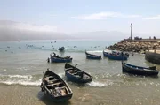 Wellenreiter und Fischer teilen sich die Brandung in Imsouane an der Atlantikküste.
