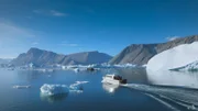 Das Teamboot auf offener See, umgeben von Eisbergen.
