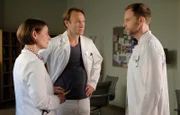 Chefarzt Dr. Kai Hoffmann (Julian Weigend, re.) hätte gern eine Begründung, warum Dr. Stein (Bernhard Bettermann, mi.) die Untersuchung einer Patientin trotz gewisser Warnsignale nach hinten verschoben hat. Doch da stellt sich Dr. Maria Weber (Annett Renneberg, li.) vor Martin. Auch sie hatte keine ernsthaften Bedenken. Als Maria sich zu Wort meldet, schaltet Kai einen Gang zurück.