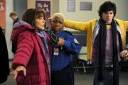 Weil Frankie (Patricia Heaton, l.) ihren Koffer heillos überpackt, müssen sie, Axl (Charlie McDermott, r.) und der Rest der Hecks sich all ihre Klamotten überziehen. Das kommt der Sicherheitsbeamtin (Luenell Campbell, M.) etwas Spanisch vor ...