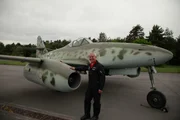 Ein Mann steht vor einem Flugzeug.