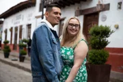 Kadie Fallowfield and Alejandro Lopez-Alvarado standing cuddling on the street outside some shops.